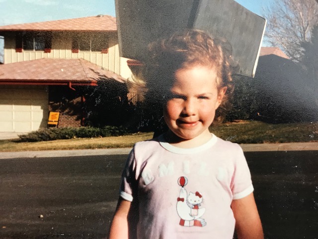 child in front of house